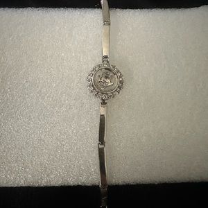 Coach bracelet watch silver center piece is horse & carriage